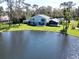 Back of home overlooking a pond and lush green lawn with screened porch, aerial view at 5348 Saddlebrook Way # 2, Wesley Chapel, FL 33543