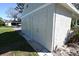 Three-car garage exterior with white doors and concrete base, next to a grassy yard at 5348 Saddlebrook Way # 2, Wesley Chapel, FL 33543