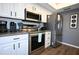 Well-lit kitchen features stainless steel appliances, ample white cabinetry, and dark countertops at 5348 Saddlebrook Way # 2, Wesley Chapel, FL 33543