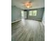 Spacious bedroom featuring wood-look floors, a ceiling fan, and natural light from the windows at 55 Harbor View Ln # 108, Belleair Bluffs, FL 33770