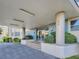 Building entrance with pillars, exterior lighting, tile accents, and manicured landscaping at 55 Harbor View Ln # 108, Belleair Bluffs, FL 33770