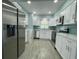 Kitchen with stainless steel appliances, stylish backsplash, and white cabinetry at 55 Harbor View Ln # 108, Belleair Bluffs, FL 33770