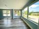 Inviting light-filled living room with blue walls and gray flooring complemented by expansive windows with outdoor views at 55 Harbor View Ln # 108, Belleair Bluffs, FL 33770