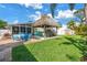 Backyard with tiki hut bar area, outdoor seating and lush green grass at 6630 Gulfport S Blvd, South Pasadena, FL 33707