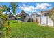 Wide backyard featuring a tiki hut, upper deck, shed, and lush lawn at 6630 Gulfport S Blvd, South Pasadena, FL 33707
