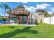 Backyard showing tiki hut, outdoor bar, steps to deck, and green lawn at 6630 Gulfport S Blvd, South Pasadena, FL 33707