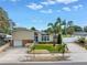 Inviting front exterior with manicured lawn, palm trees, and unique architectural details under a partly cloudy sky at 6630 Gulfport S Blvd, South Pasadena, FL 33707