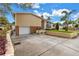 Exterior shot showing the garage and driveway, complemented by manicured landscaping and a partially cloudy sky at 6630 Gulfport S Blvd, South Pasadena, FL 33707