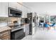 Modern kitchen featuring stainless steel appliances, granite countertops, and seamless flow into the dining area at 6630 Gulfport S Blvd, South Pasadena, FL 33707