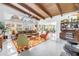 Bright living room featuring exposed beam ceilings, large windows, and an open layout with modern furnishings at 6630 Gulfport S Blvd, South Pasadena, FL 33707