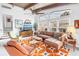 Inviting living room featuring exposed-beam ceilings, a large window, and stylish decor with cozy, retro furniture at 6630 Gulfport S Blvd, South Pasadena, FL 33707