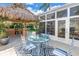 Backyard featuring a tiki hut with seating, patio, and view of the sunroom attached to the home at 6630 Gulfport S Blvd, South Pasadena, FL 33707