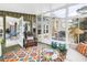 Sunroom with seating area, bright rug, and view to outdoor living space at 6630 Gulfport S Blvd, South Pasadena, FL 33707
