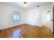 Clean and simple bedroom with hardwood floors, large window, white trim, and closet space at 6920 Bougainvilla S Ave, St Petersburg, FL 33707