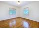 Bedroom showcases hardwood floors, white walls, and two windows with blinds at 6920 Bougainvilla S Ave, St Petersburg, FL 33707