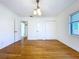 Bright bedroom featuring hardwood floors, white walls and trim, with a vintage chandelier and closet at 6920 Bougainvilla S Ave, St Petersburg, FL 33707