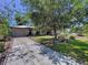 Beautiful home exterior with a well-maintained lawn, mature tree, and inviting driveway, showcasing curb appeal at 6920 Bougainvilla S Ave, St Petersburg, FL 33707