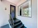 Charming front porch with blue door, metal railing, and a black accent step at 6920 Bougainvilla S Ave, St Petersburg, FL 33707