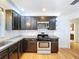 Well-lit kitchen boasts dark cabinets, stainless steel appliances and bright white tile backsplash at 6920 Bougainvilla S Ave, St Petersburg, FL 33707