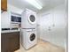 Well-lit laundry room with stacked washer and dryer, sink, and tile flooring at 6920 Bougainvilla S Ave, St Petersburg, FL 33707