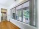 Bright living room with hardwood floors, large window with backyard view, and white trim at 6920 Bougainvilla S Ave, St Petersburg, FL 33707