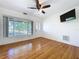 Inviting living room featuring hardwood floors, front view window, ceiling fan, and a wall-mounted television at 6920 Bougainvilla S Ave, St Petersburg, FL 33707