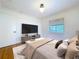 Serene main bedroom with a TV, neutral décor, hardwood floors, white walls, and a window view at 6920 Bougainvilla S Ave, St Petersburg, FL 33707