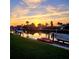 Waterfront property at sunset featuring private dock, boat, kayaks, and manicured lawn at 781 Binnacle Point Dr, Longboat Key, FL 34228