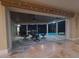 Charming covered patio featuring a ceiling fan and picturesque views of the pool and waterway at night at 781 Binnacle Point Dr, Longboat Key, FL 34228