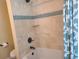 Bathtub and shower with blue accent tile and a shower curtain at 781 Binnacle Point Dr, Longboat Key, FL 34228