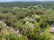 Aerial view showcases the expansive property, with a pool, mature trees, and lush landscaping at 876 Ranch Rd, Tarpon Springs, FL 34688