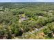 Aerial view features a luxurious home with a pool, set amidst a backdrop of verdant trees at 876 Ranch Rd, Tarpon Springs, FL 34688