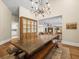 A dining room with a wooden table and benches, showcasing the open floor plan into the living room at 876 Ranch Rd, Tarpon Springs, FL 34688