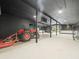 Spacious garage for parking and storage, featuring modern lighting and tractor with mower at 876 Ranch Rd, Tarpon Springs, FL 34688