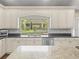 Elegant kitchen with white cabinets, granite countertops, and stainless steel appliances at 876 Ranch Rd, Tarpon Springs, FL 34688