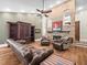 Living room with a brick fireplace, leather furniture, built in shelves, ceiling fan, and hardwood floors at 876 Ranch Rd, Tarpon Springs, FL 34688