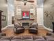 Living room with a brick fireplace, leather furniture, ceiling fan, and hardwood floors at 876 Ranch Rd, Tarpon Springs, FL 34688
