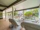 Spacious covered outdoor patio featuring wicker seating, ceiling fan, and views of the backyard at 876 Ranch Rd, Tarpon Springs, FL 34688