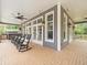 A cozy screened porch with rocking chairs, ceiling fans, and views of the backyard at 876 Ranch Rd, Tarpon Springs, FL 34688