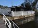 Backyard with a white fence and screened enclosure on the canal with a dock, showcasing waterfront living and privacy at 8822 Rocky Creek Dr, Tampa, FL 33615