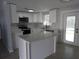 Modern kitchen with white cabinets, stainless steel appliances, and a center island, offering style and functionality at 8822 Rocky Creek Dr, Tampa, FL 33615