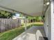 Backyard patio area provides a shaded retreat, complemented by the green lawn and privacy fence at 10275 117Th Dr, Largo, FL 33773