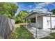 Charming backyard featuring a covered patio area, verdant grass, and a wooden privacy fence at 10275 117Th Dr, Largo, FL 33773