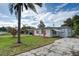 A well-maintained house front exterior with a neat lawn and mature palm tree at 10275 117Th Dr, Largo, FL 33773