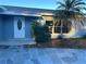 Close-up view of a front door with stone walkway, landscaping, and palm tree at 11096 117Th Way, Seminole, FL 33778