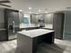 Modern kitchen with grey cabinets, an island, stainless steel appliances, and luxury flooring at 11096 117Th Way, Seminole, FL 33778