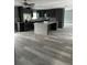 An open concept kitchen with island, gray cabinets, stainless steel appliances, and luxury vinyl flooring at 11096 117Th Way, Seminole, FL 33778