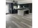 An open concept kitchen with island, gray cabinets, stainless steel appliances, and luxury vinyl flooring at 11096 117Th Way, Seminole, FL 33778