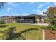 Well-maintained backyard with a screened lanai, lush landscaping, and manicured lawn at 11142 Spring Point Cir, Riverview, FL 33579