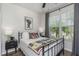 Bright bedroom featuring a black metal bed frame, wood floors, and lots of natural light at 11142 Spring Point Cir, Riverview, FL 33579